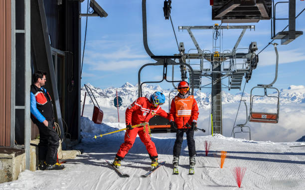 Older man and teenager get off chairlift at ski resort with majestic Italian alps in background Pila, Aosta, Italy - Feb 19, 2018: Older man and teenager get off chairlift at ski resort with majestic Italian alps in background pila stock pictures, royalty-free photos & images