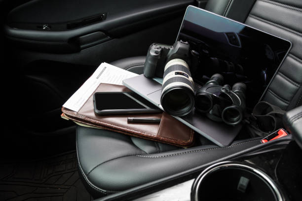 Private investigator tools on car seat Tools for private investigation including camera, smartphone, laptop and binoculars military private stock pictures, royalty-free photos & images