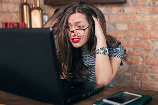 istock Young freelancer girl is working hard in laptop in loft interior 923498254