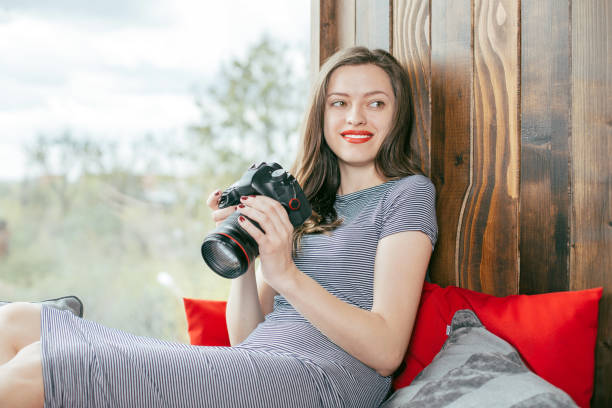 istock Young freelancer girl with a camera in loft interior 923500960