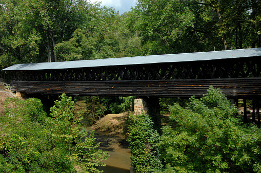 Extra long Clarkson Covered Bridge, near Cullman, Alabama, covered Crooked Creek.  Wooden bridge has tin roof.