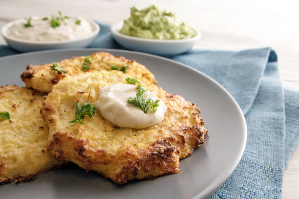 smażone rosti warzywne z kalafiora, jajka i parmezanu z dipami i dekoruj pietruszką na niebieskim talerzu, z bliska - roesti zdjęcia i obrazy z banku zdjęć