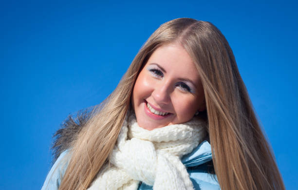 istock Smiling girl on blue sky background in park 923508884