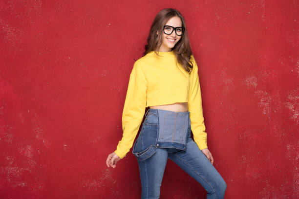 istock Happy girl smiling, standing on red background. 923512690