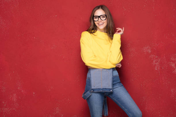 Happy girl smiling, standing on red background.