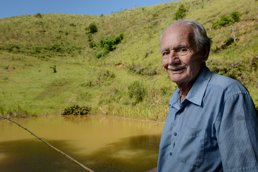 Portrait of a Brazilian farmer with over 80 years old fishing in a lake.
