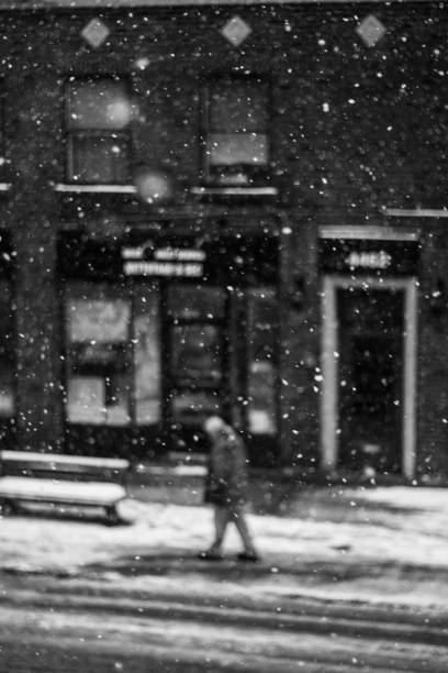istock man walking in the city while snowing 923523062