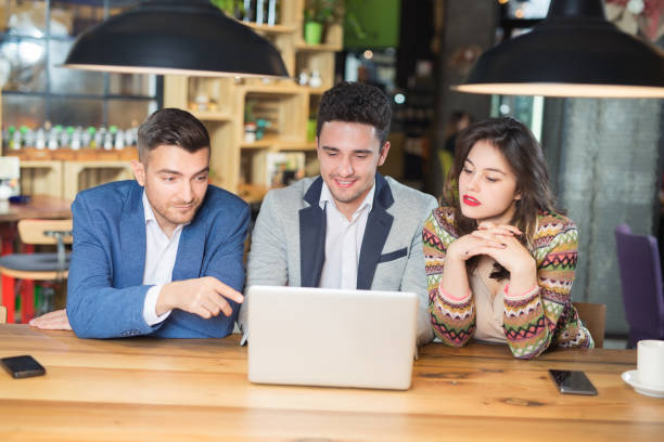 istock Three Businesspeople Working At Laptop In cafe 923523310