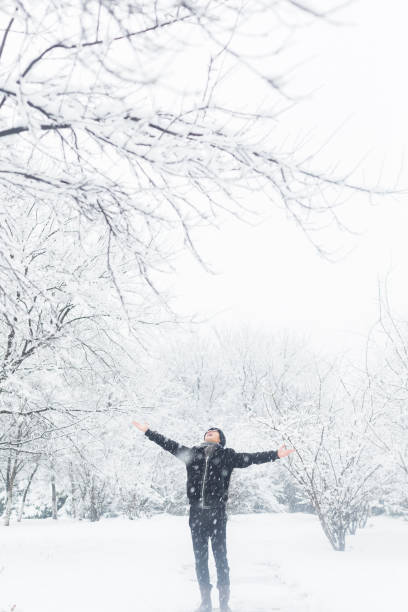 istock young man stretching his arms in the snow 923543942