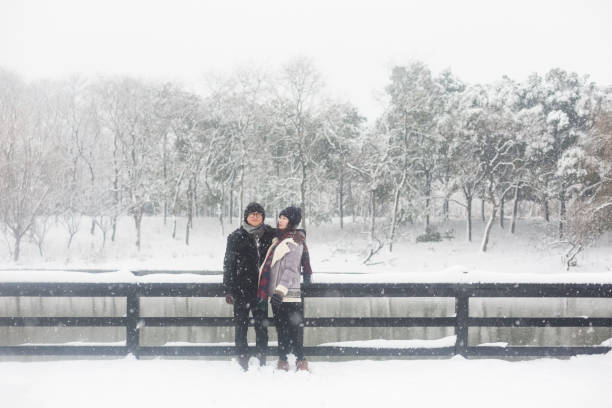 istock young couple standing on a snow-covered wooden bridge 923546428