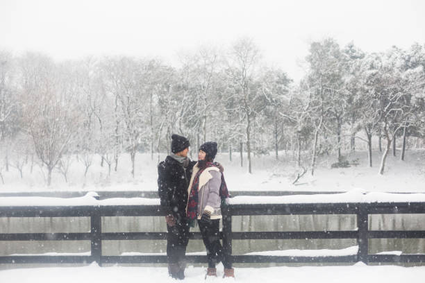 istock young couple standing on a snow-covered wooden bridge 923546444