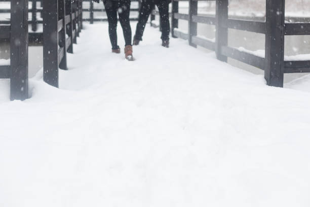 Close up of boots on feet, child walking in snow in winter.
