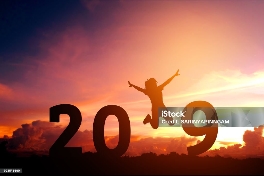 Silhouette giovane donna che salta al capodanno 2019 - Foto stock royalty-free di Cambiamento