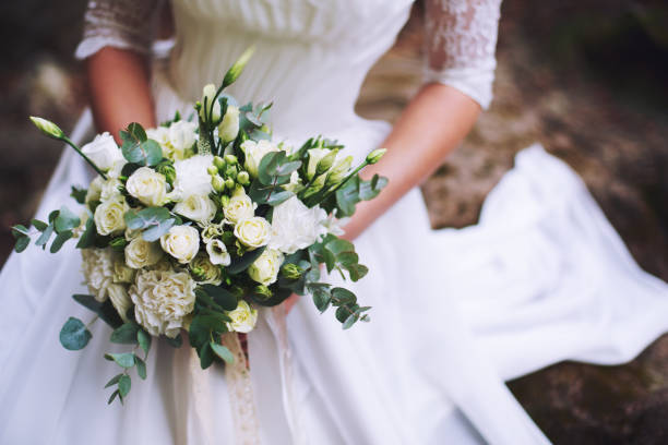 female hands holding a wedding bouquet of flowers from roses - bride wedding fashion evening gown imagens e fotografias de stock