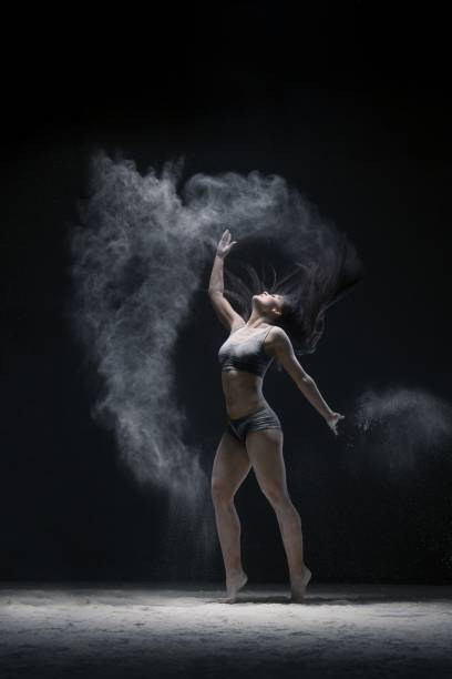 istock Woman jumping gracefully in dust cloud view 923556396