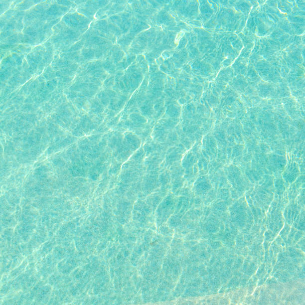 istock Swimming pool blue water with a wave and sunlight reflection 923565918