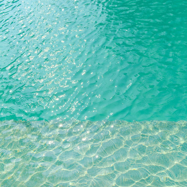 istock Swimming pool blue water with a wave and sunlight reflection 923565988