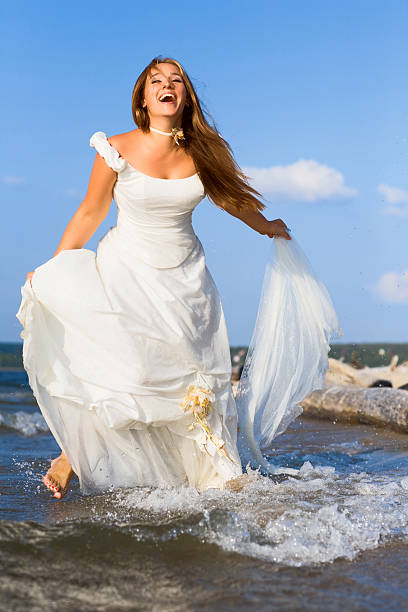 istock running laughing bride on the sea 92356727