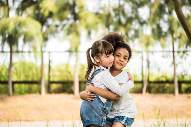 istock Cheerful little girls hugging in a park. 923575082