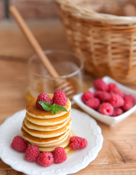 istock Pancakes with raspberry on wooden table. smiley face. 923577542