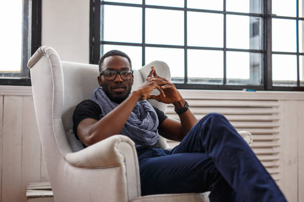 istock A black man relaxing  in a white chair. 923582364