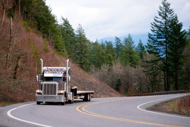 고전적인 큰 장비 세미 트럭 세미 트레일러 나무와 통해 구불구불한도 내려 단계 - lumber industry truck truck driver log 뉴스 사진 이미지