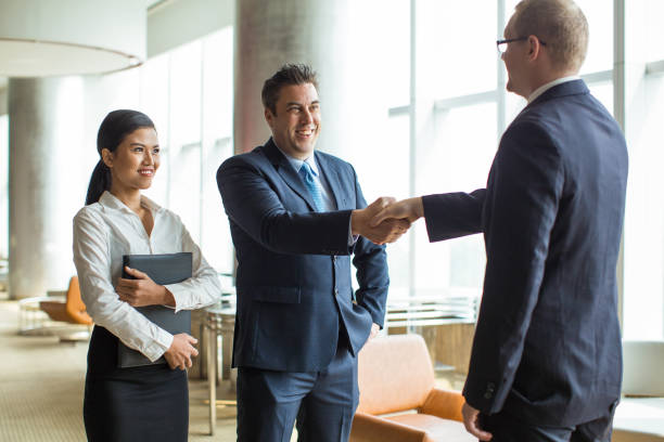 istock Smiling ceo and his assistant greeting partner 923588406