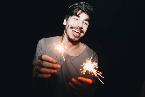 istock Caucasian man playing with sparklers celebration and festive party concept 923588864