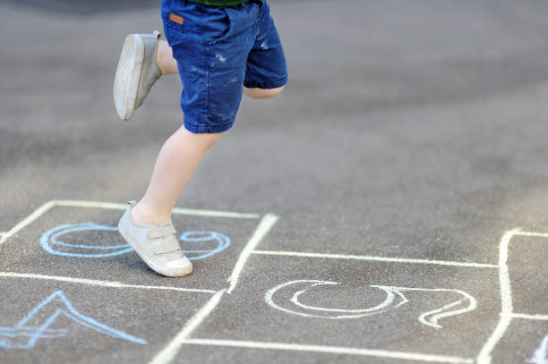 istock Cute blond boy playing hopscotch game after school 923592626