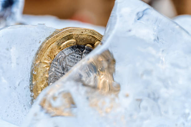 istock Frozen New British one pound sterling coin up close macro inside ice cubes 923593008