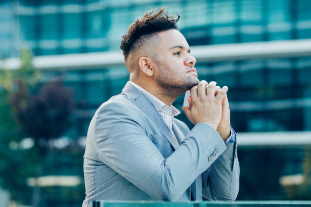 Pensive successful businessman walking in city