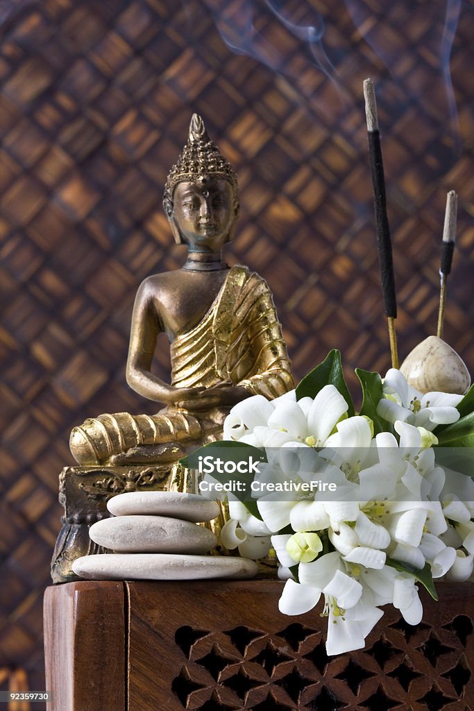 Buddha con varillas de incienso y flores - Foto de stock de Asia del Este libre de derechos
