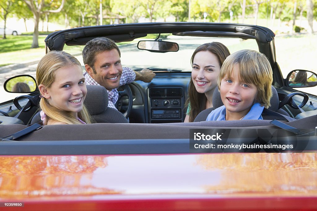 Young family in red convertible smiling for camera Family in convertible car smiling 30-39 Years Stock Photo