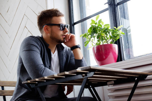 istock A man in sunglasses sitting at the table. 923598790