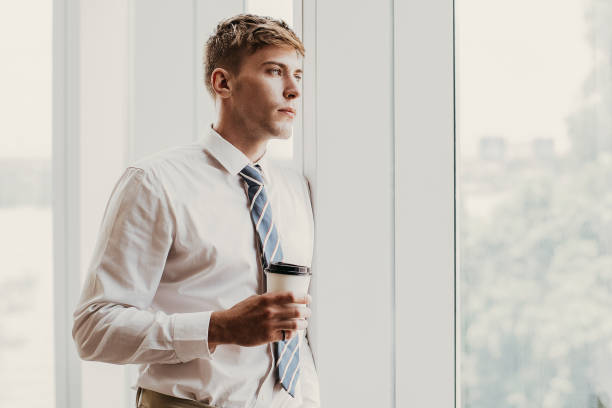 istock Serious Business Man at Window With Drink 923602086