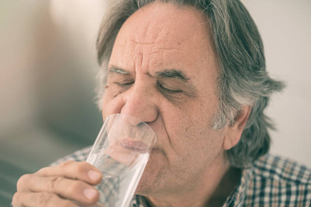 istock Senior man drinking glass of water inside 923602630