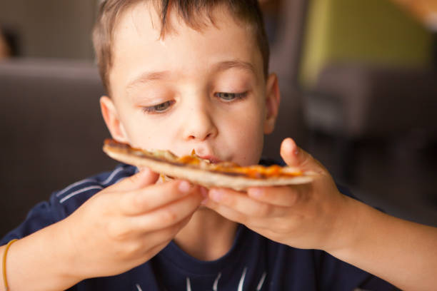 Child  having fun eating pizza  bar restaurant stock photo