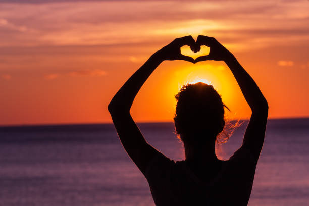 istock Girl holding a heart - shape symbol with her hands / fingers. 923610564
