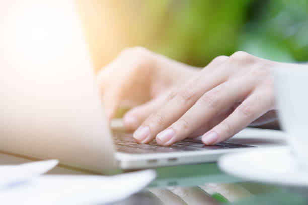 istock Asian woman hands has touching and typing on laptop computer with blurred coffee, computer and view outside window. 923611792