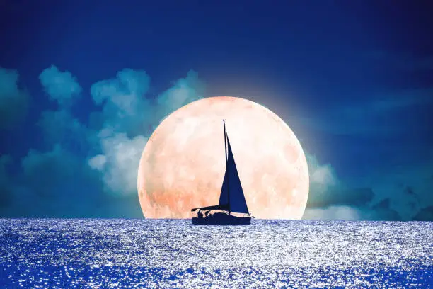 Photo of Silhouette of a boat with full Moon on the ocean. My astronomy work.