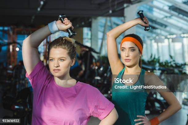 Sportlich Und Übergewichtigen Frauen Training Mit Hanteln Im Fitnessstudio Stockfoto und mehr Bilder von Dick
