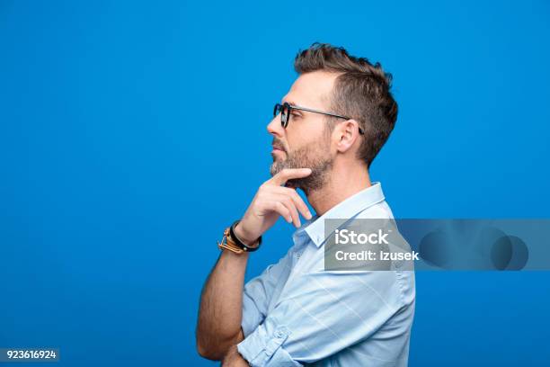 Side View Of Confident Handsome Man Blue Background Stock Photo - Download Image Now