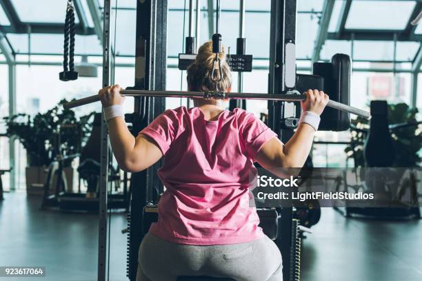 Overweight Woman Working Out On Training Apparatus Stock Photo - Download Image Now - Overweight, Exercising, Relaxation Exercise