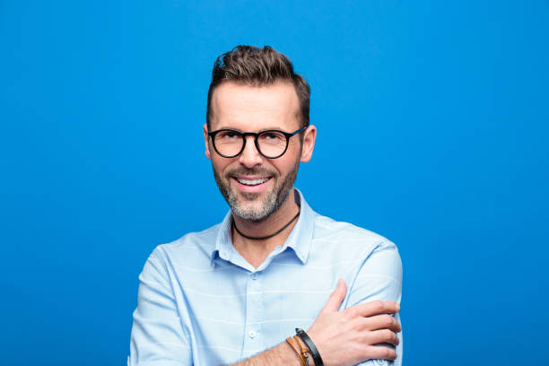 istock Summer portrait of handsome smiling man, blue background 923617420