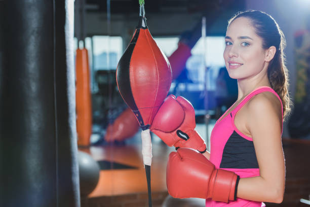 istock sporty woman in boxing mitts looking at camera 923617596