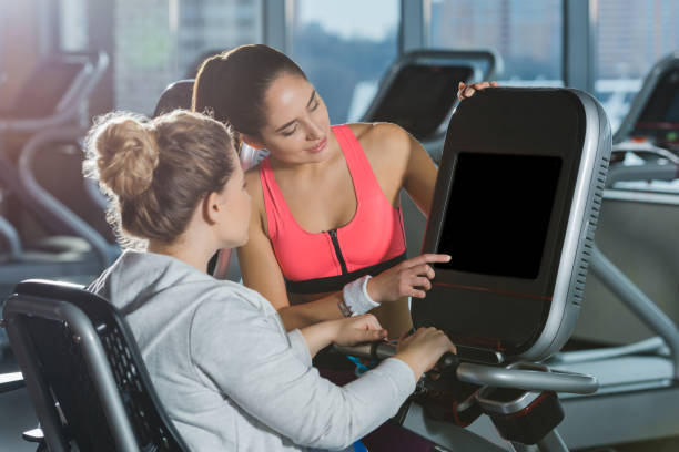 istock overweight woman starting to doing cardio while trainer helping her 923618400