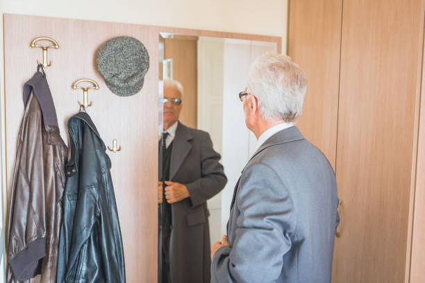 istock Grandfather looking himself in the mirror, getting dressed 923627030