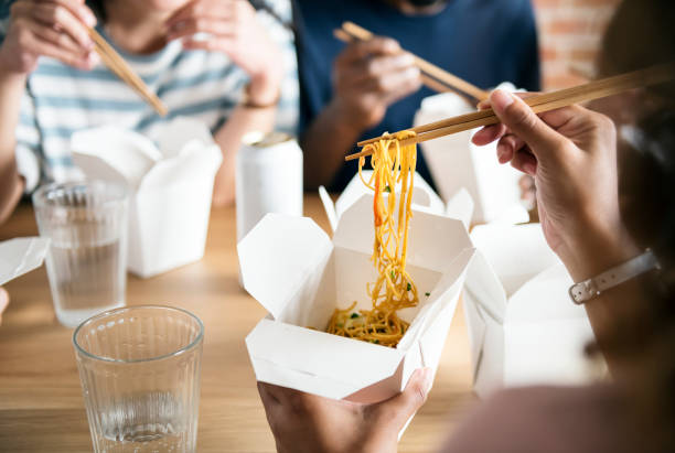Friends eating Chow mein together Friends eating Chow mein together chinese takeout stock pictures, royalty-free photos & images