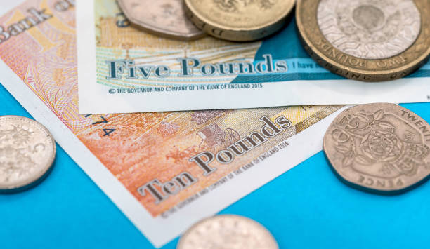 istock British Pound money bills and coin on blue 923630696