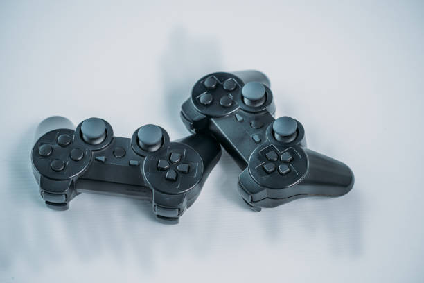 close up view of black gamepads for playing video game on grey tabletop